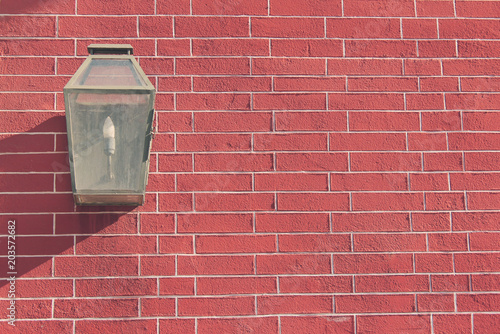 House Brick Wall with Classic Small Street Lantern. Vintage Architecture Building Exterior, Red Brick Wall Background and Classic Retro Lantern Lamp. Outdoor Close Up View of Old Brick House Front.