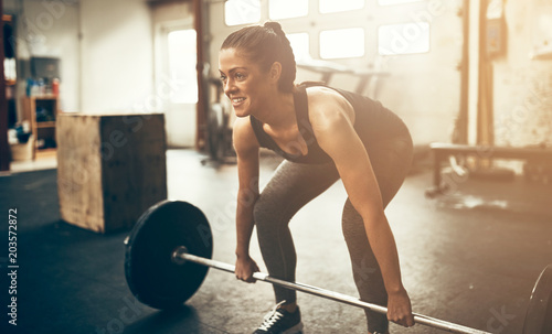 Young woman smiling during a weight session in the gym