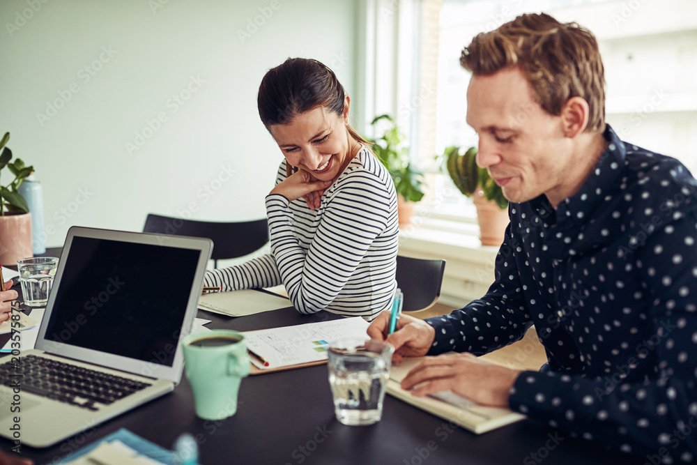 Fototapeta premium Smiling business colleagues going over paperwork together in an