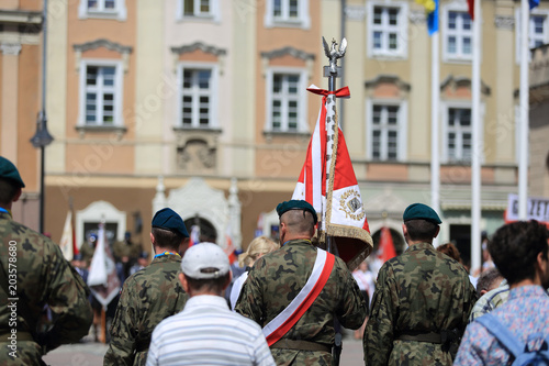 Żołnierze Wojska Polskiego z flagą na rynku w Opoluw dniu Święta Flagi.
