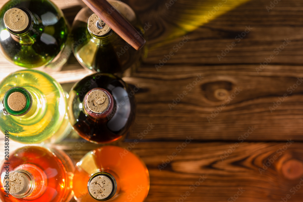 Wine bottles standing against wooden background