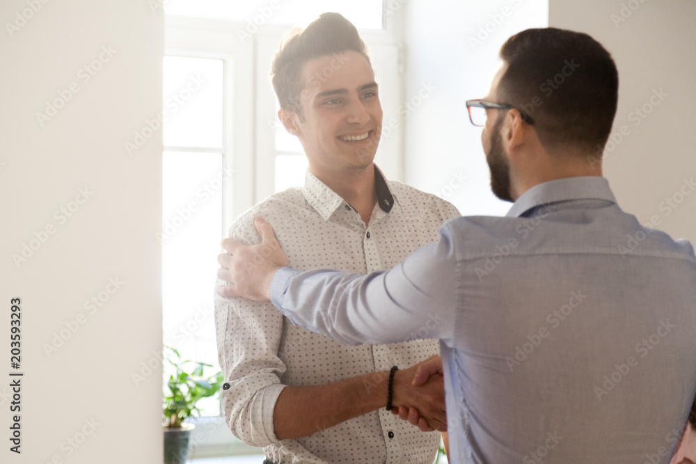 Grateful boss handshaking employee congratulating with job promotion, appreciating good results, friendly ceo proud of subordinate shaking hand expressing gratitude, recognition, support and respect Grateful boss handshaking employee congratulating with job promotion, appreciating good results, friendly ceo proud of subordinate shaking hand expressing gratitude, recognition, support and respect