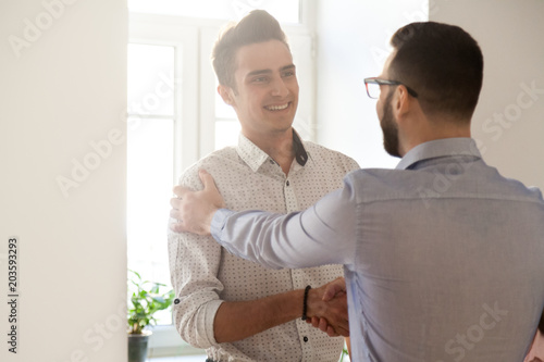 Grateful boss handshaking employee congratulating with job promotion, appreciating good results, friendly ceo proud of subordinate shaking hand expressing gratitude, recognition, support and respect