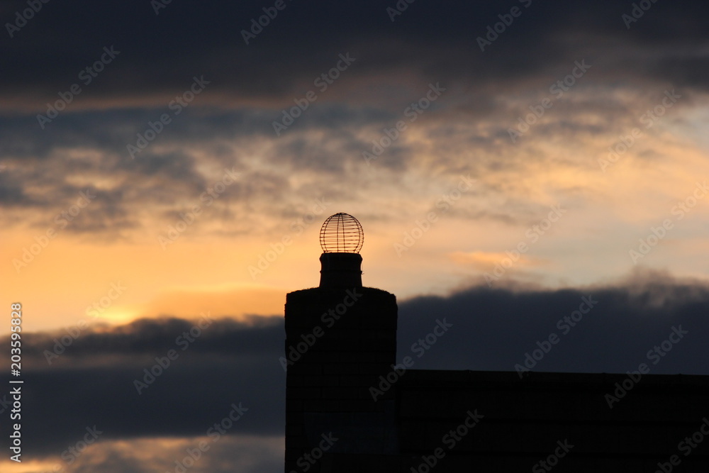 Chimney pot in silhouette at dusk