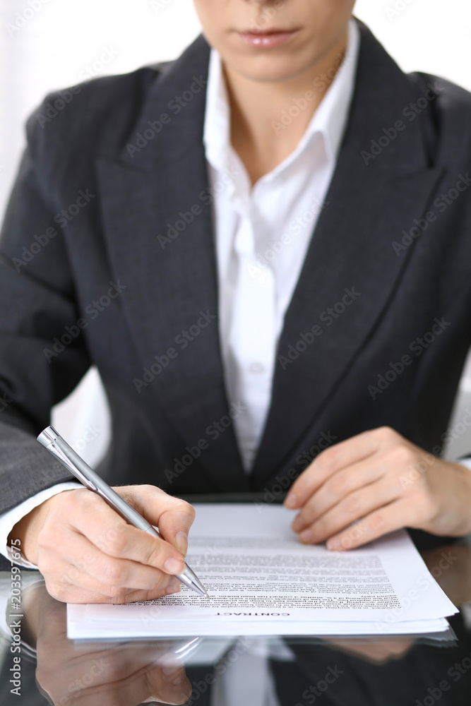 Obraz premium Close-up of female hands with pen over document, business concept