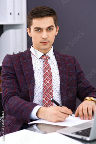 Young man working with laptop computer, man's hands on notebook, business person at workplace