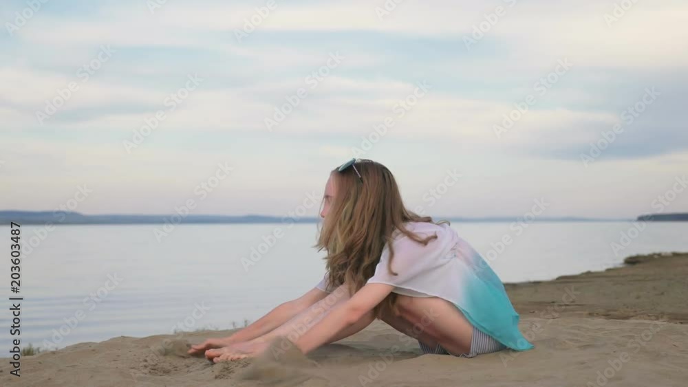 One beautiful teenage girl with brown hair outside on a beautiful summer day. The woman is sitting on the beach. The sun was gone in the sunset. She smiles, laughs, sometimes sad. One beautiful teenage girl with brown hair outside on a beautiful summer day. The woman is sitting on the beach. The sun was gone in the sunset. She smiles, laughs, sometimes sad.