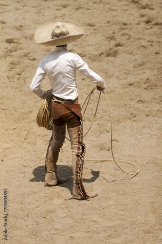Mexican charro standing bravely holding his lasso with right hand