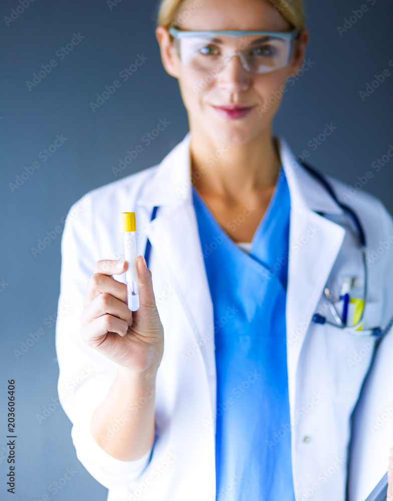 Female medical or research scientist or doctor using looking at a test tube of clear solution in a lab or laboratory. Female medical or research scientist or doctor using looking at a test tube of clear solution in a lab or laboratory.