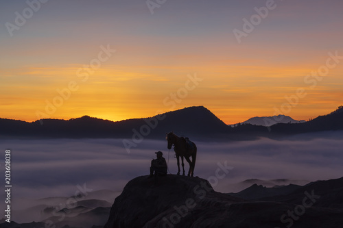 BROMO, INDONESIA - 16th APRIL 2018; Silhouette of unidentified local people or Bromo Horseman at the mountainside of Mount Bromo, Semeru, Tengger National Park, East Java of Indonesia.