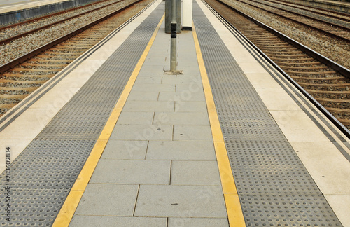 Train platform with train tracks on either side.