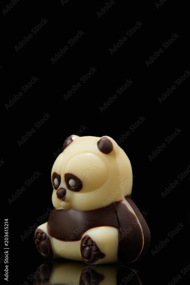 Fototapeta premium closeup shot of panda shaped chocolate on black background