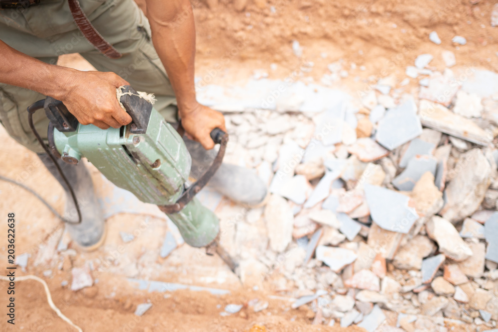 Worker using concrete extractor machine to Destroy concrete Worker using concrete extractor machine to Destroy concrete