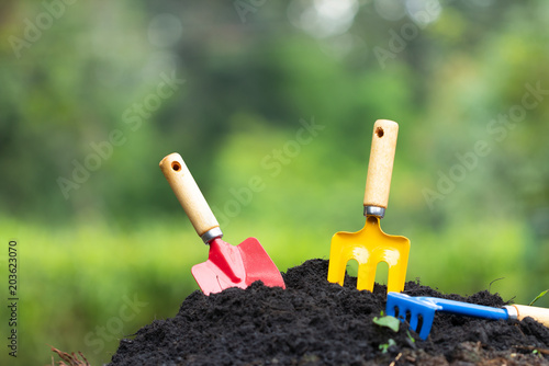 Tools garden soil and hydrangea flower in flower pot over nature background. Concept for gardening and agriculture