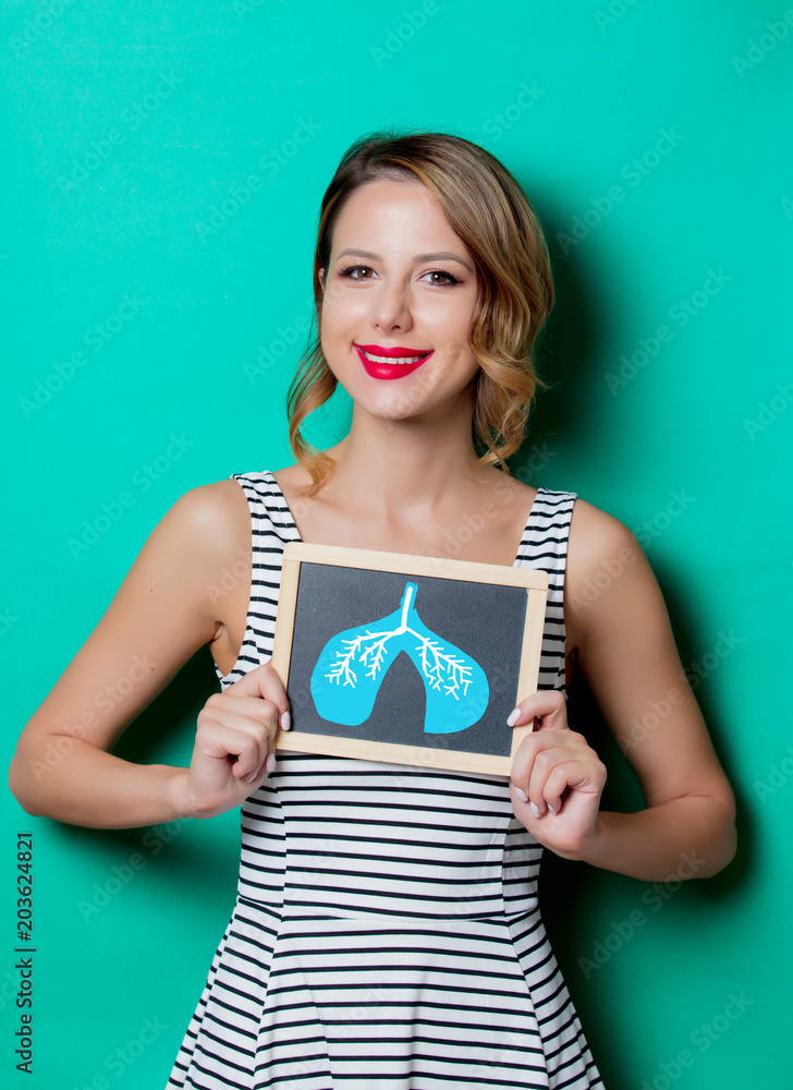 Young girl holding a board with demonstration of good condition of lungs on green background Young girl holding a board with demonstration of good condition of lungs on green background