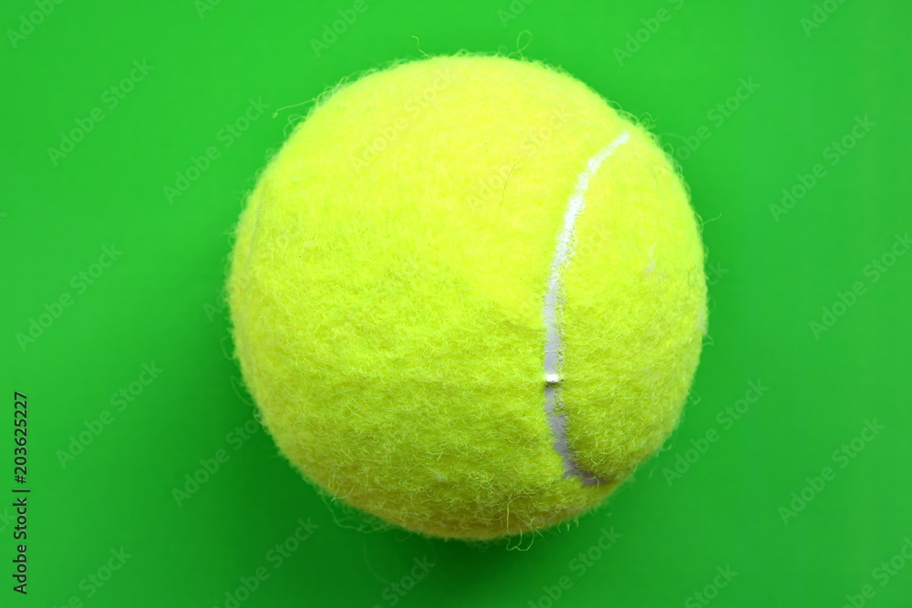 yellow tennis ball on bright green background