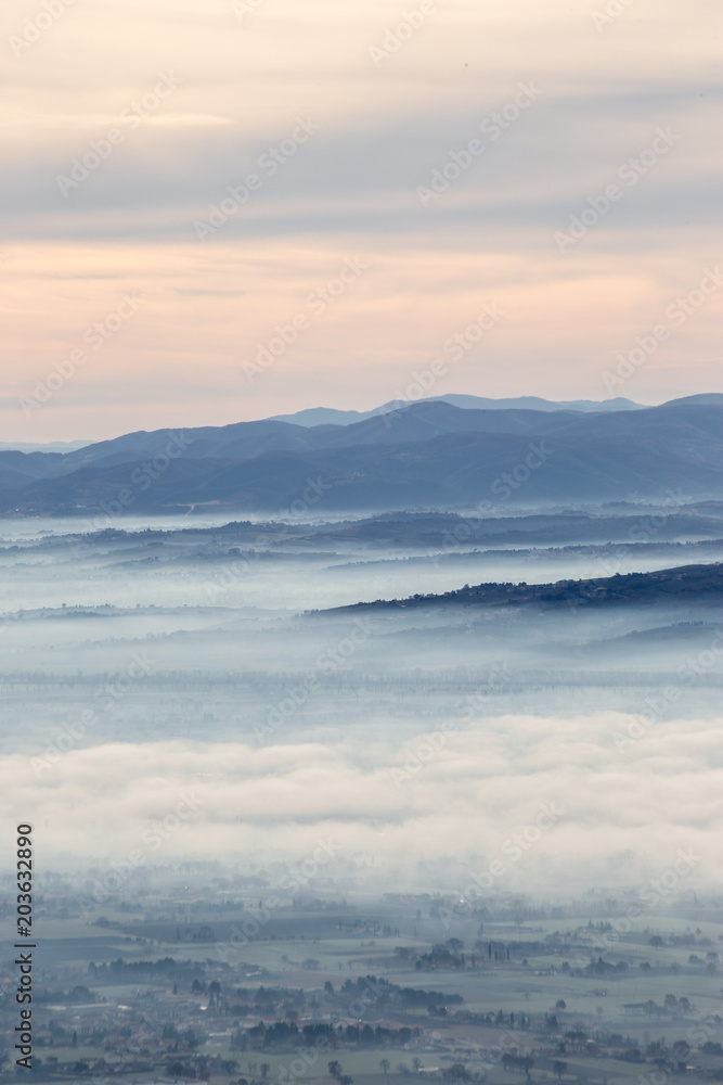 Obraz premium Beautiful aerial view of Umbria valley in a winter morning, with fog covering trees and houses