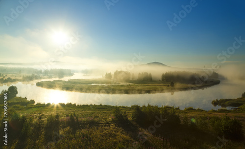 Beautiful sunrise flight sun over misty river foggy morning . Summer fog and sun on peaceful river. Holiday destination, place for rest, meditative state