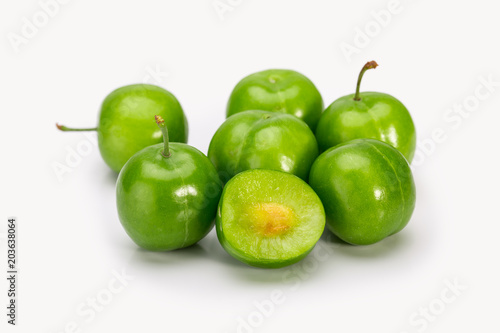 Close Up Of Green Plums Or Greengage showing the flesh and the seed of the fruit Isolated On White Background, Popular Spring Fruits With A Very Sharp Sour Taste Originated In Iran