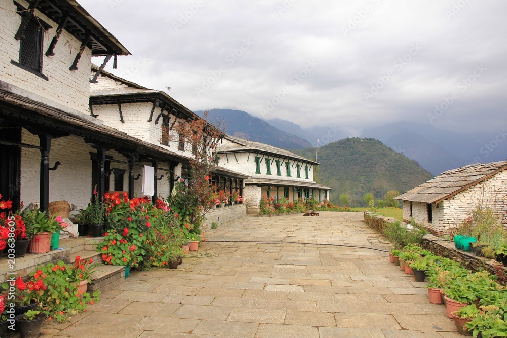 Traditional architecture in Ghandruk, Annapurna Conservation Area, Nepal. Flowers in front of a row old houses. Traditional architecture in Ghandruk, Annapurna Conservation Area, Nepal. Flowers in front of a row old houses.