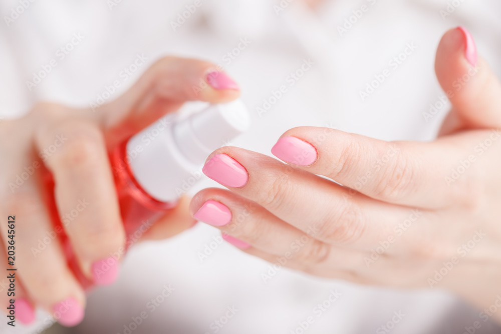 Woman`s hands spraying perfume Woman`s hands spraying perfume