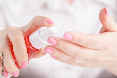 Woman spraying insect repellent on her hand