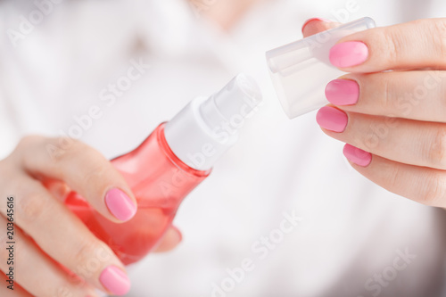 Woman`s hands spraying perfume