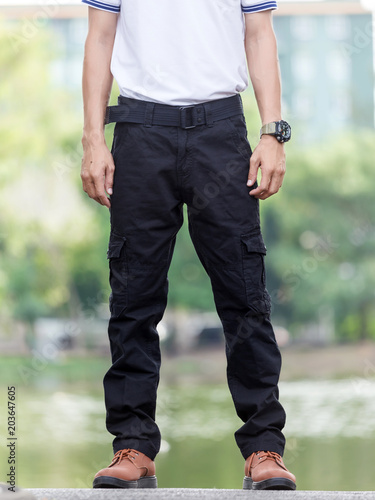 man wearing black cargo pants and standing in the nature park