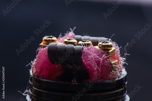 Vape close-up with wet cotton wool on black background photo