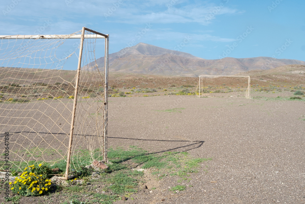 Football pitch on arid ground.