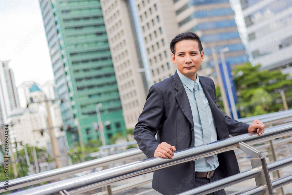 Asia young business man in front of the modern building in downtown .Concept of young business people Asia young business man in front of the modern building in downtown .Concept of young business people