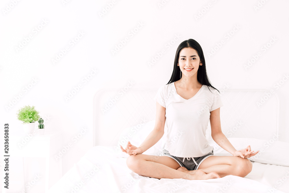 Woman practicing yoga at home in bedroom Woman practicing yoga at home in bedroom