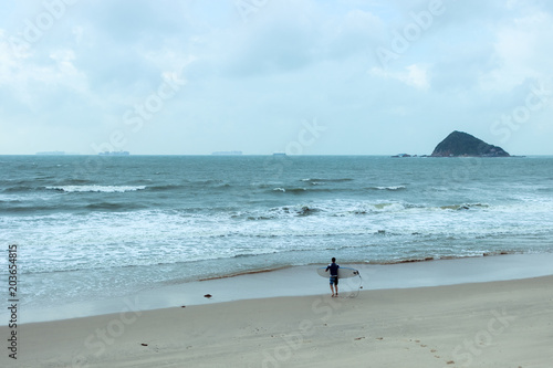 cold morning on coast with surfer goes to the sea to swim 