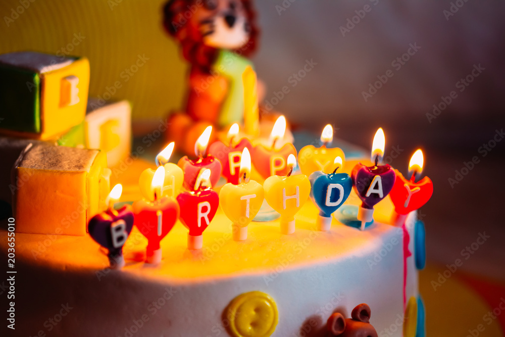Happy Birthday Written In Lit Candles On Colorful Cake