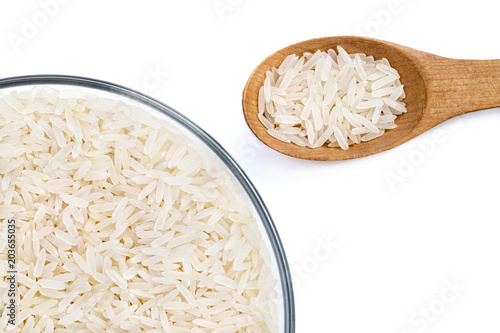 Close up of parboiled rice in glass bowl and wooden spoon on white background. Healthy food. Top view. High resolution product.