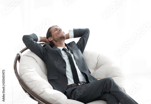 young businessman meditating in big comfortable armchair © ASDF