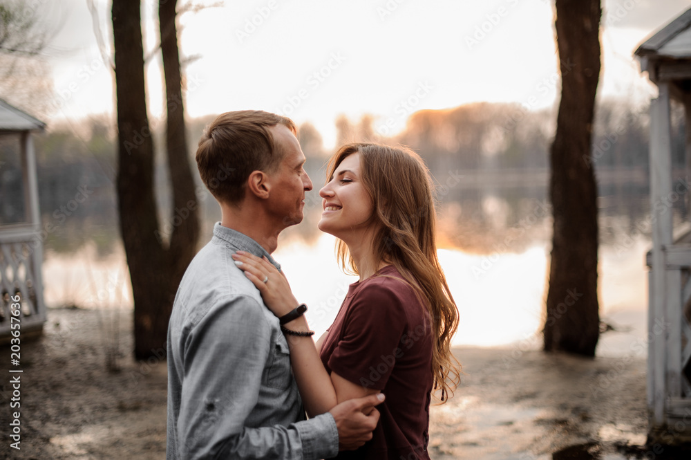 Couple in love watching each other eyes on the background of lake Couple in love watching each other eyes on the background of lake