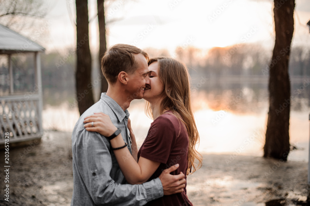 Couple in love standing together on the background of lake