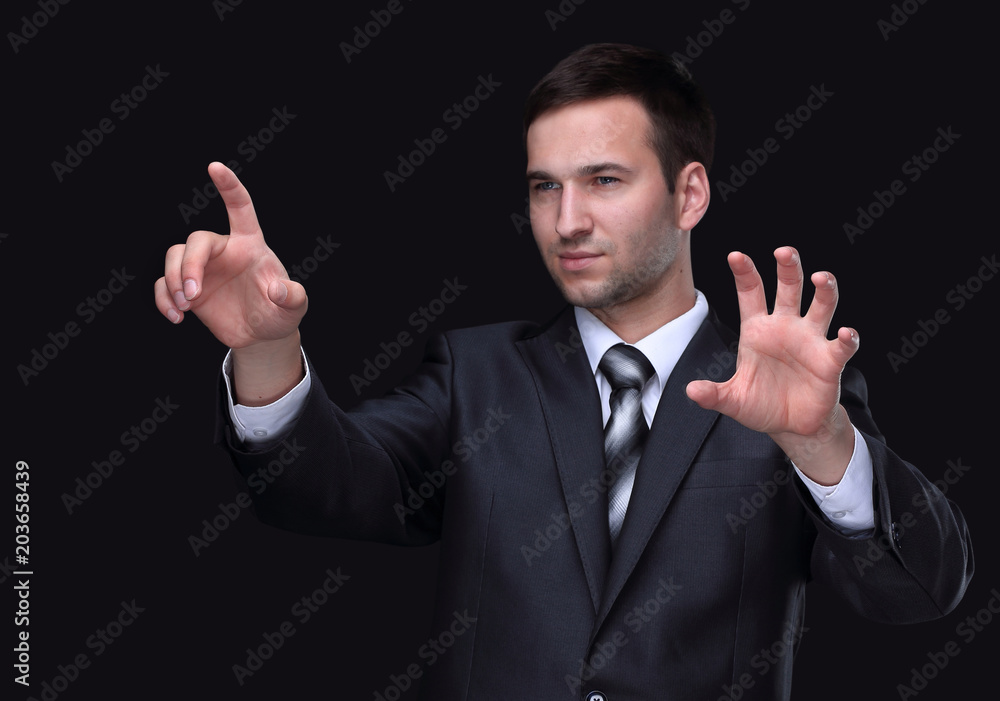 businessman pointing to a blank spot.isolated on a black background. businessman pointing to a blank spot.isolated on a black background.