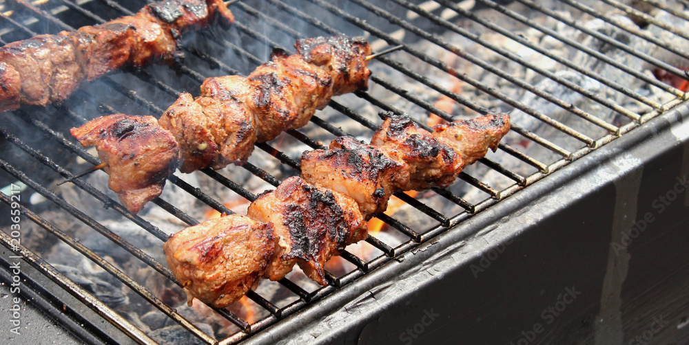 Closeup of some meat skewers being grilled in a barbecue Closeup of some meat skewers being grilled in a barbecue