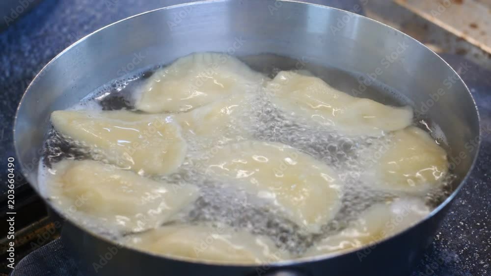 Dumplings cooking in a pan with stainless steel, bubbling water Dumplings cooking in a pan with stainless steel, bubbling water
