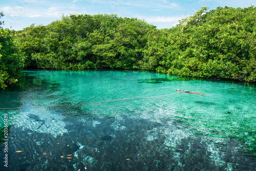 Woman floating in a nature cenote in Riviera Maya, Mexico