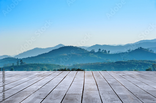 wooden table and beautiful landscape view of mountain ranges against with blue sky