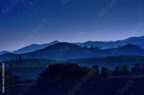 starry night with beautiful landscape view of hill layers against with blue night sky