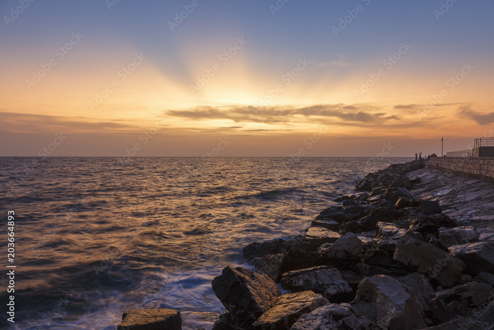 Colorful sunset on a beach with rocks on the Adriatic Sea coast Istria
