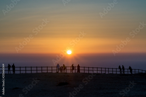 Silhouettes enjoing a sunset at the coast photo