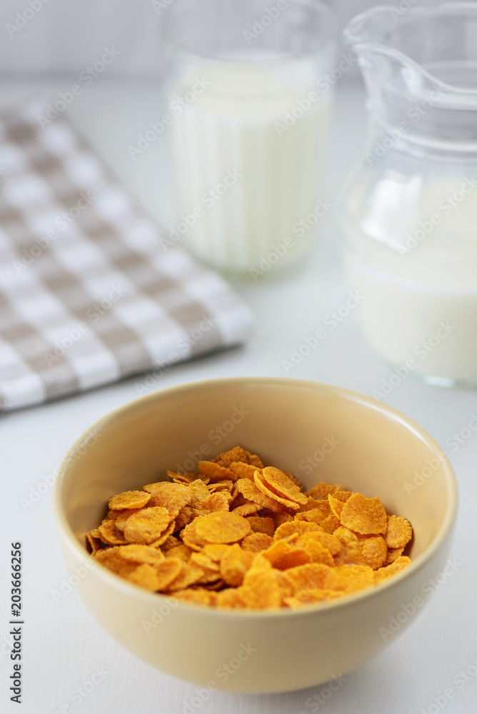 corn flakes with milk in a plate on a white table corn flakes with milk in a plate on a white table