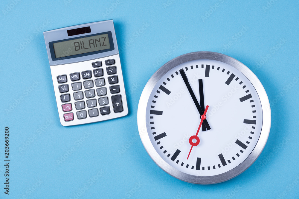 Taschenrechner mit den Worten Bilanz und einer Uhr Taschenrechner mit den Worten Bilanz und einer Uhr