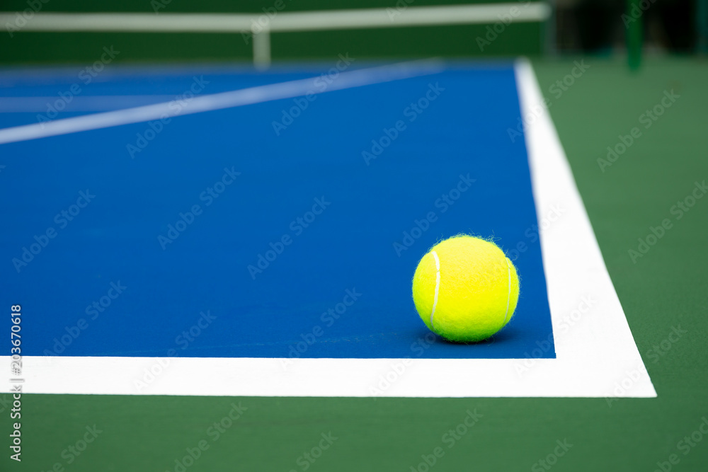 Tennis ball on a blue tennis court
