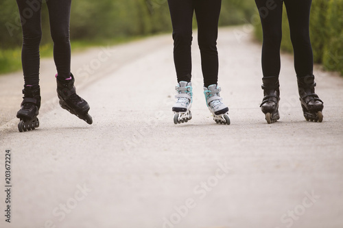 Close-up view of group of female legs on roller skates